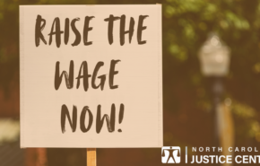 "Raise the wage NOW!" on protest sign.